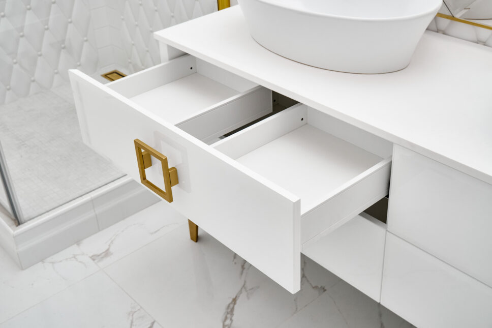 White cabinet with open drawer and vessel sink in bathroom