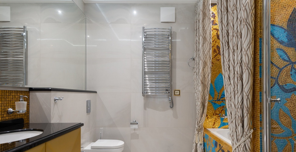 wall mounted towel rack in bathroom with yellow mosaic